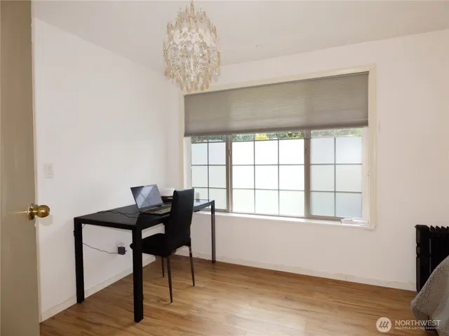 a view of a workspace with furniture and a window