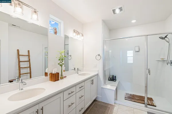 a bathroom with a double vanity sink toilet and shower