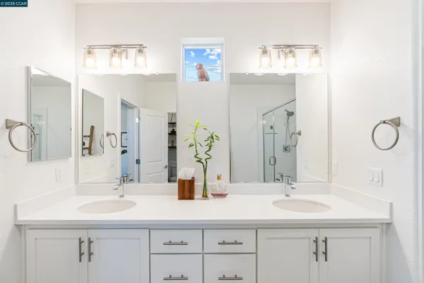 a bathroom with double vanity sinks and a mirror