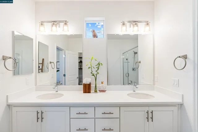 a bathroom with double vanity sinks and a mirror
