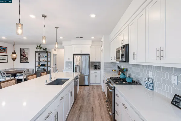 a kitchen with stainless steel appliances kitchen island granite countertop a sink stove and refrigerator