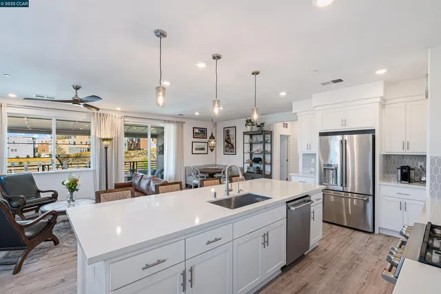 a kitchen with stainless steel appliances a refrigerator sink and chairs