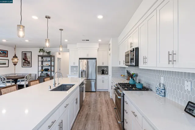 a kitchen with stainless steel appliances kitchen island granite countertop a sink stove and refrigerator