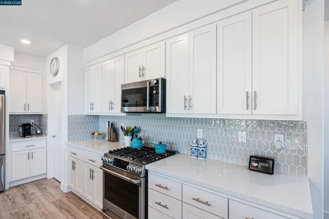 a kitchen with white cabinets and appliances