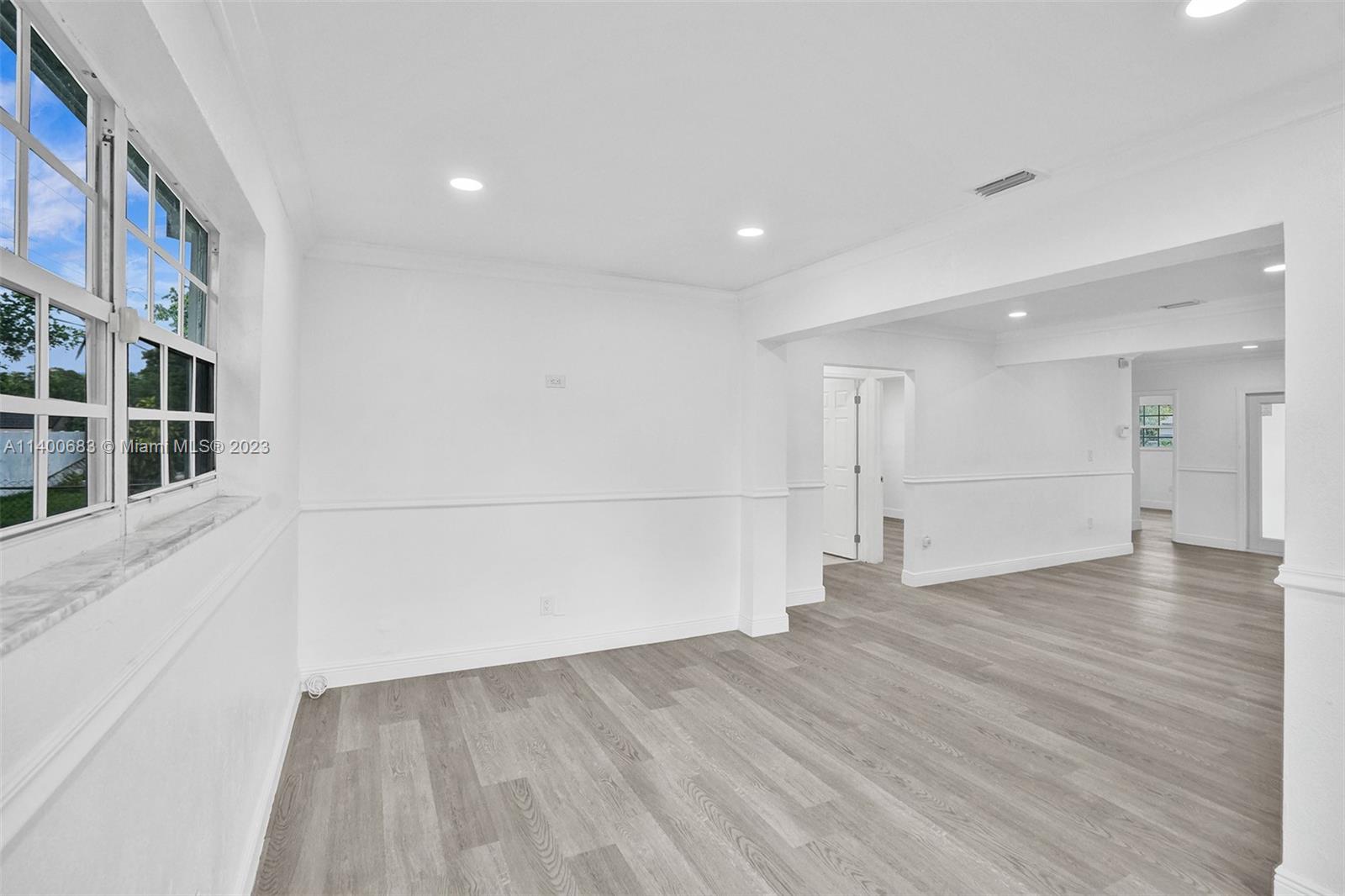 7813 Granada Boulevard Miramar, FL 33023 - Photo 11 of 35 a view of empty room with wooden floor and windows