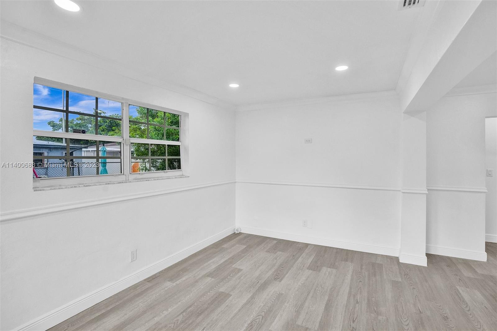7813 Granada Boulevard Miramar, FL 33023 - Photo 12 of 35 an empty room with wooden floor and windows
