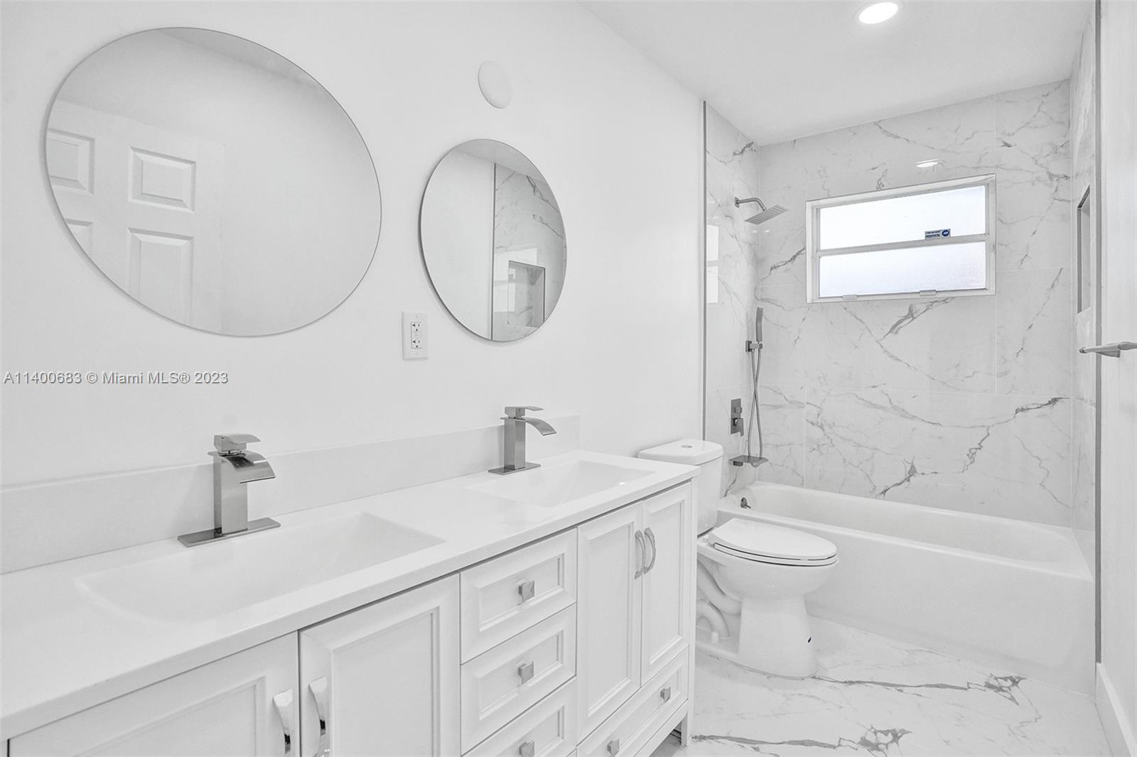 7813 Granada Boulevard Miramar, FL 33023 - Photo 15 of 35 a bathroom with a toilet a sink a mirror and bathtub