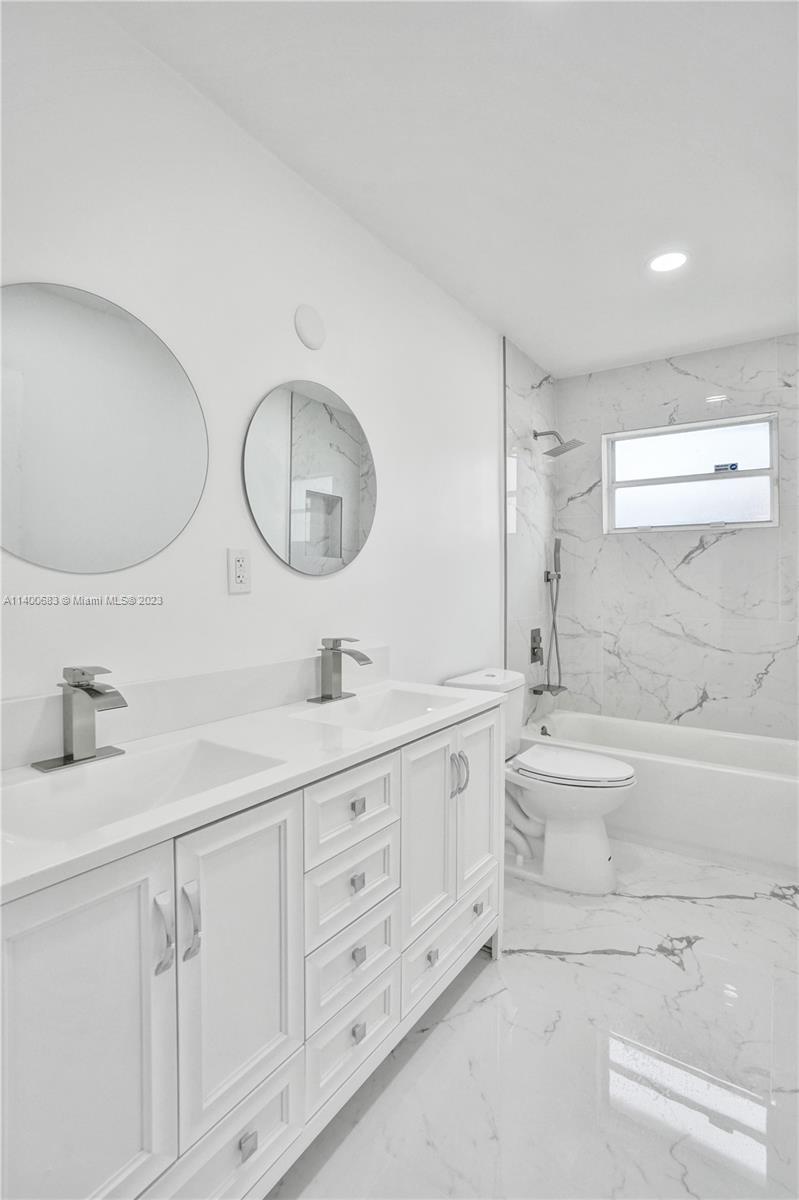 7813 Granada Boulevard Miramar, FL 33023 - Photo 18 of 35 a bathroom with a double vanity sink mirror and a
