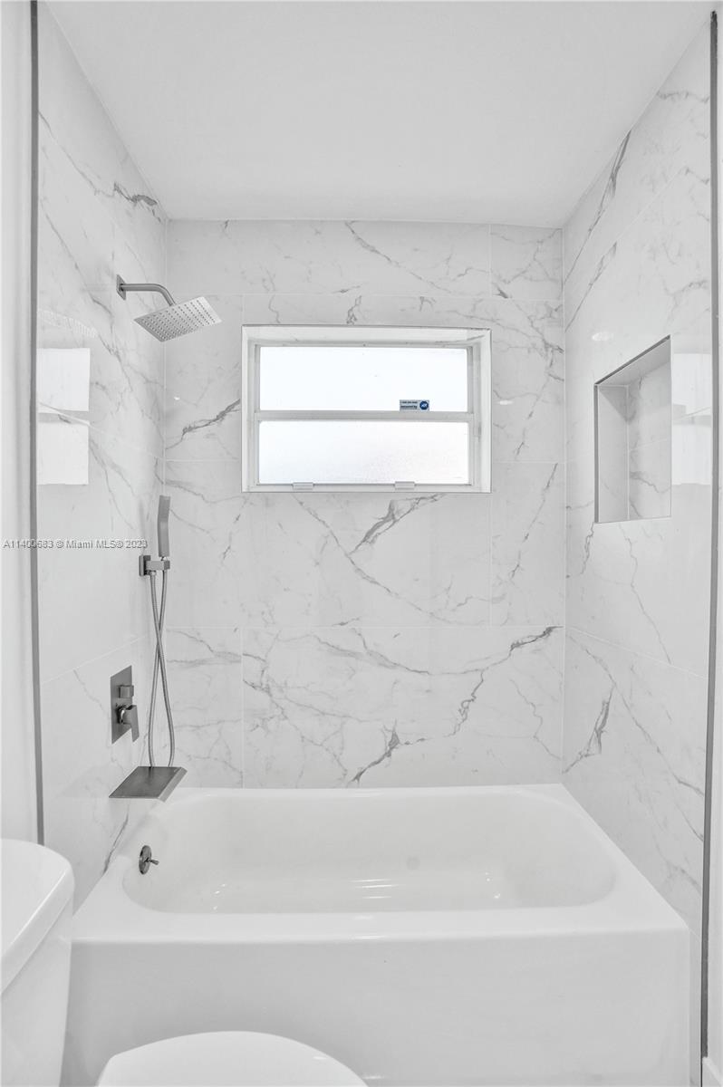 7813 Granada Boulevard Miramar, FL 33023 - Photo 19 of 35 a bathroom with a bathtub and a toilet