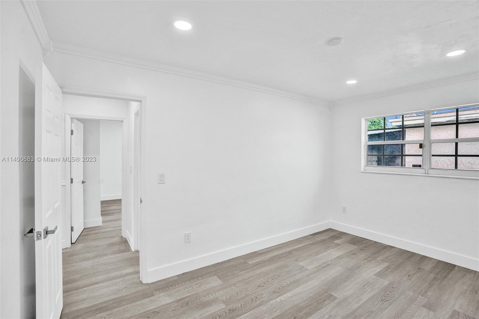 7813 Granada Boulevard Miramar, FL 33023 - Photo 21 of 35 wooden floor in an empty room with a window