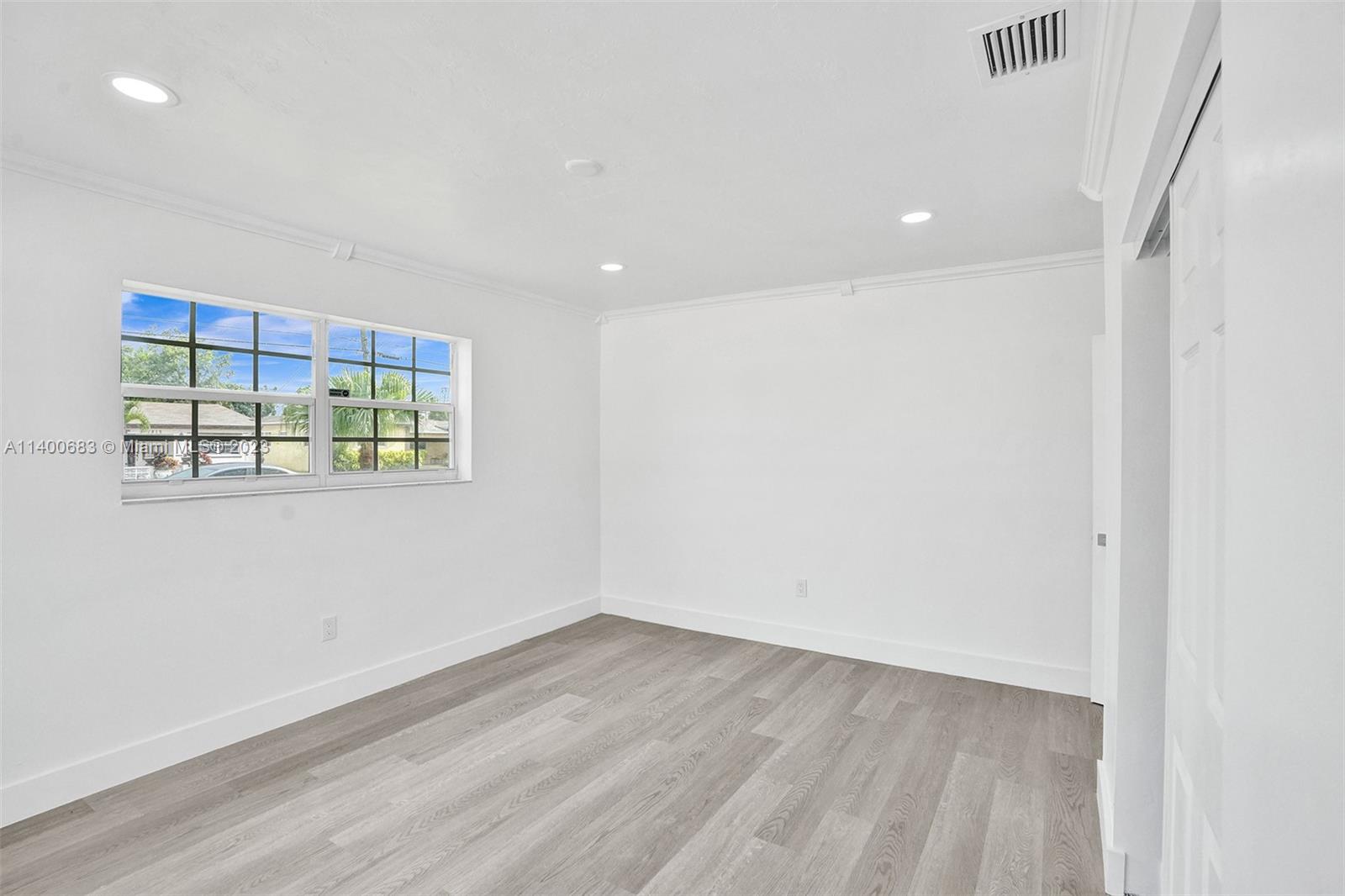 7813 Granada Boulevard Miramar, FL 33023 - Photo 27 of 35 an empty room with wooden floor and windows