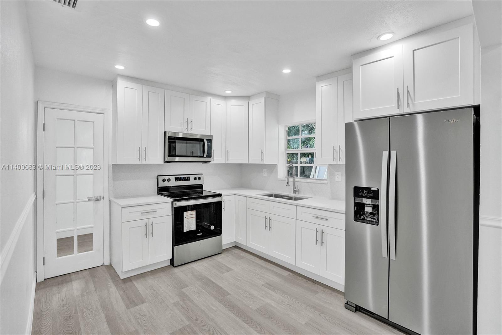 7813 Granada Boulevard Miramar, FL 33023 - Photo 4 of 35 a kitchen with white cabinets stainless steel appliances and a refrigerator