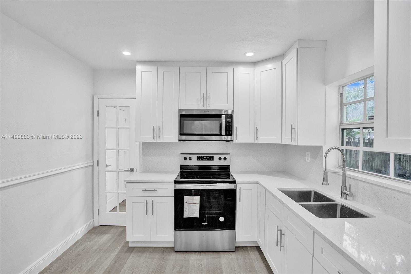 7813 Granada Boulevard Miramar, FL 33023 - Photo 9 of 35 a kitchen with white cabinets and appliances