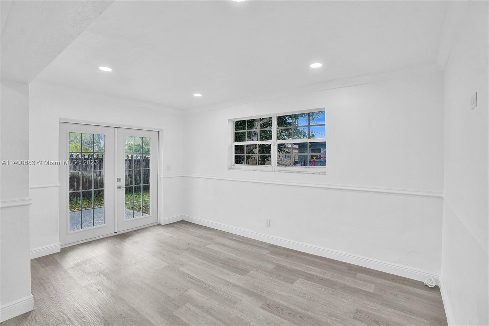 7813 Granada Boulevard Miramar, FL 33023 - Photo 10 of 35 an empty room with wooden floor and windows