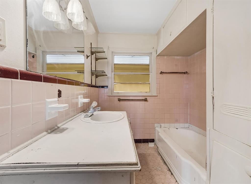 1121 Wheeler Street Texarkana, TX 75503 - Photo 11 of 14 a bathroom with a granite countertop sink a toilet and bathtub