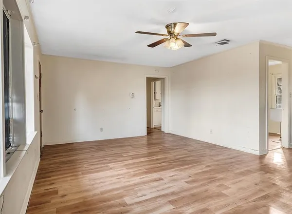 a view of a livingroom with a ceiling fan and wooden floor