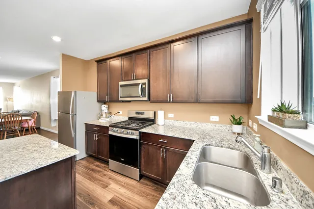 a kitchen with stainless steel appliances granite countertop a sink stove and refrigerator