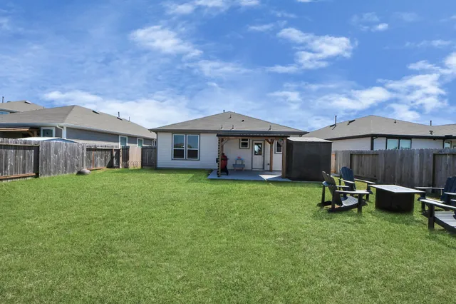 a backyard of a house with table and chairs