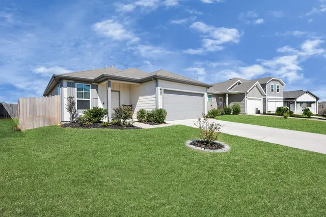 a front view of a house with a garden and yard