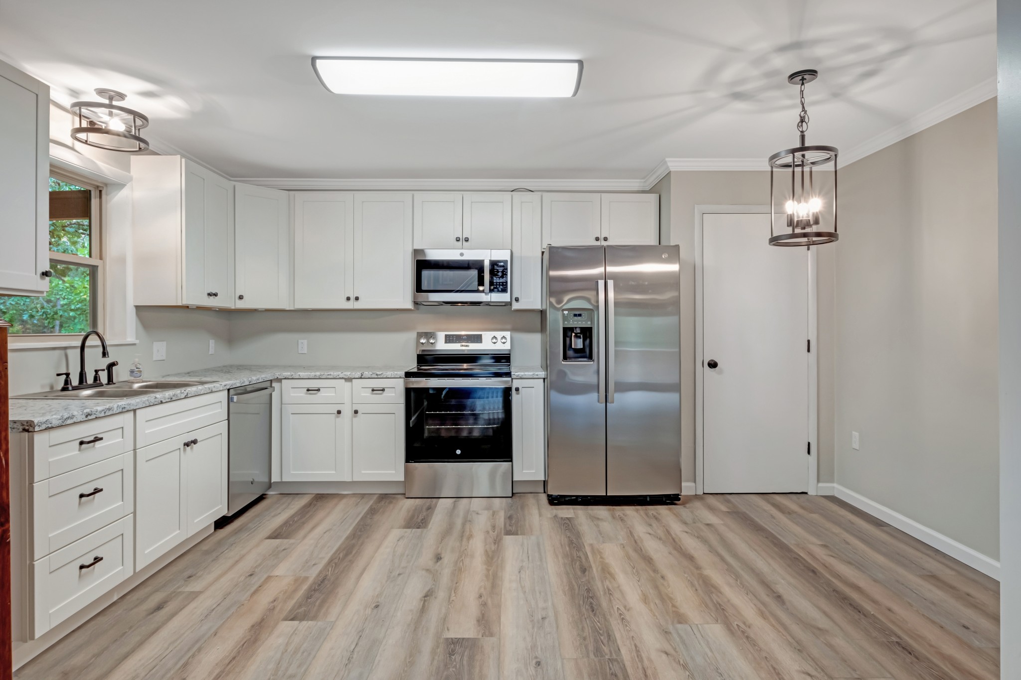 2312 Little Fish Trap Road Lawrenceburg, TN 38464 - Photo 22 of 48 a kitchen with granite countertop a refrigerator oven a sink dishwasher and wooden floor