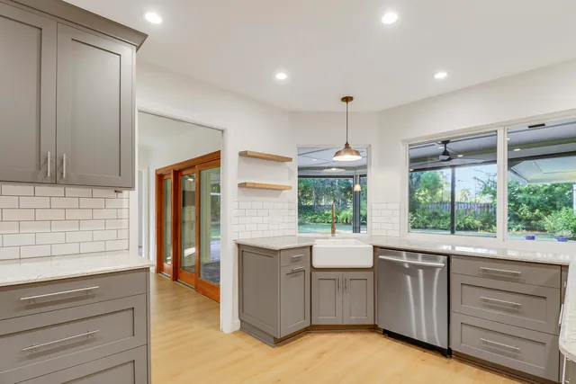 a large kitchen with stainless steel appliances a large counter top a stove and a refrigerator