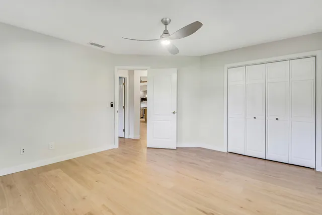 a room with a wooden floor and a ceiling fan