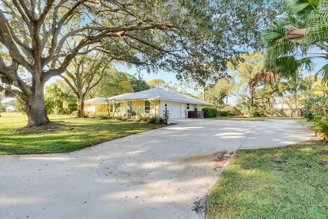 a front view of a house with yard and green space