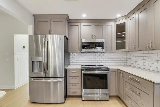 a kitchen with stainless steel appliances a refrigerator stove and microwave