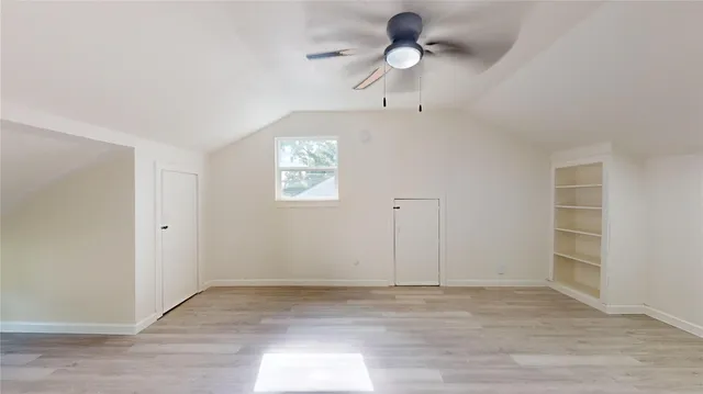 an empty room with closet and windows
