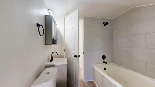 a bathroom with a tub sink and mirror