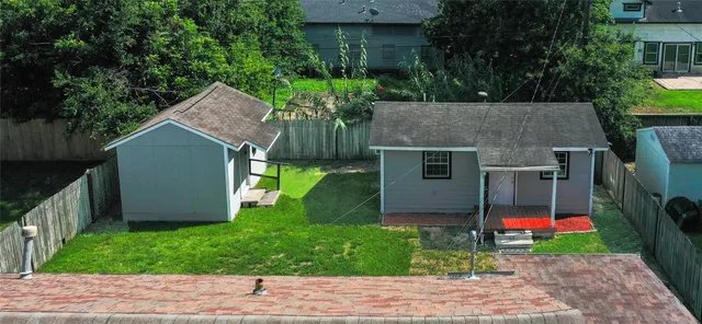 a view of backyard with potted plants and a large tree