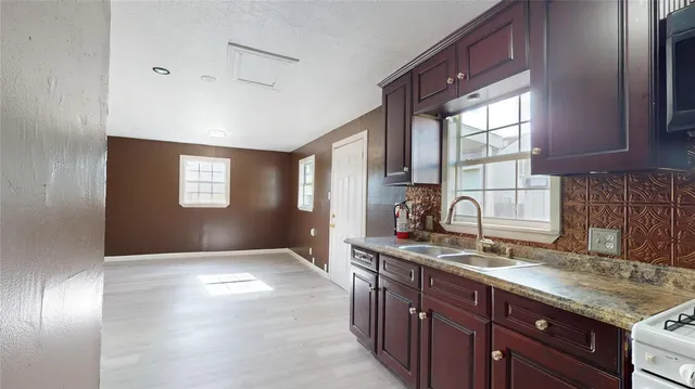 a kitchen with granite countertop a sink stainless steel appliances and cabinets