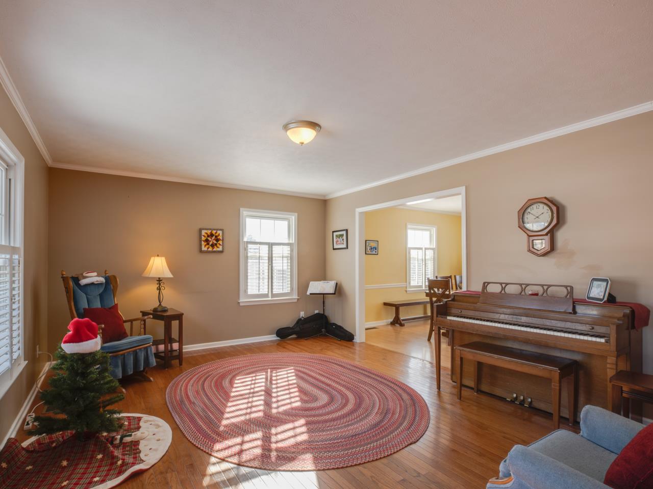 Large living room area upon entering the home.  This space offers large windows with lots of natural lighting and hardwood flooring.
