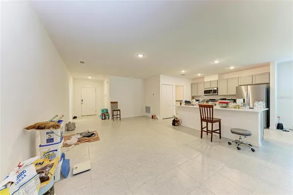 a room with kitchen island a sink wooden floor and appliances