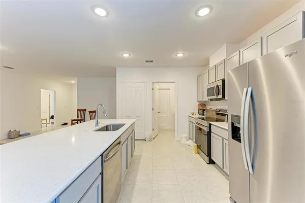 a kitchen with stainless steel appliances a stove microwave and sink