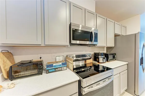 a view of a kitchen with a sink dishwasher stove and cabinets