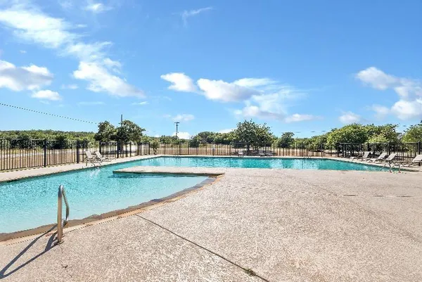 a view of a swimming pool with a yard and sitting area