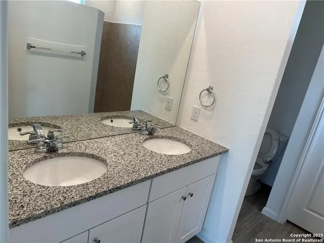 a bathroom with a granite countertop sink and a mirror