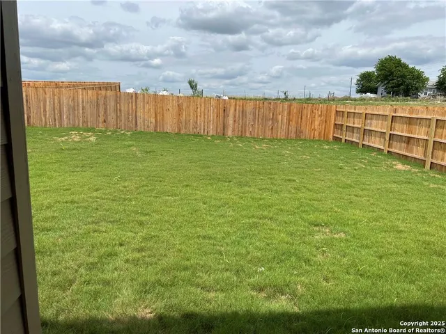a view of yard with small yard and wooden fence