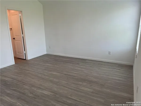 an empty room with wooden floor and closet