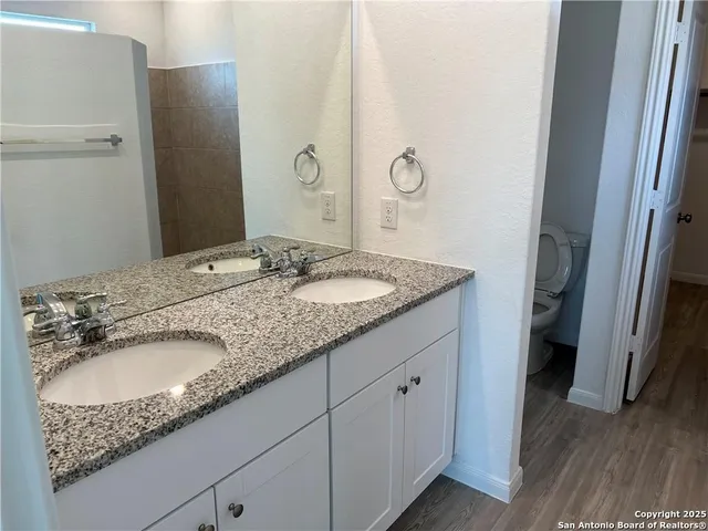 a bathroom with a granite countertop sink and a mirror