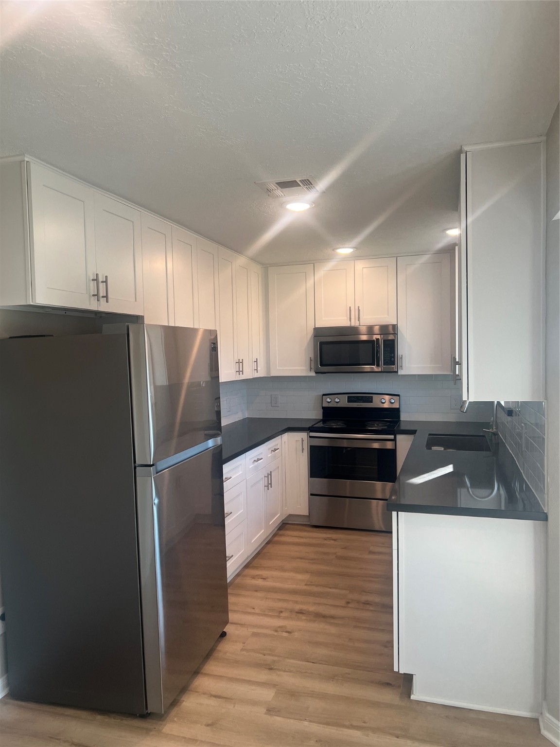 10507 Kirkdale Drive Houston, TX 77089 - Photo 4 of 7 a kitchen with granite countertop a refrigerator and a stove top oven