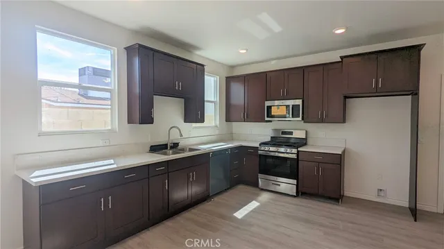 a kitchen with granite countertop stainless steel appliances cabinets a sink and a window