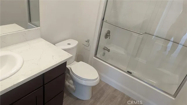 a white toilet sitting next to a bathroom sink and vanity