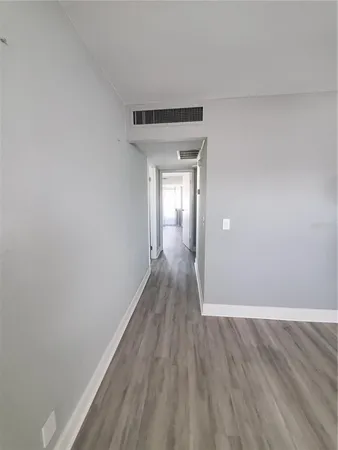 a view of a hallway with wooden floor