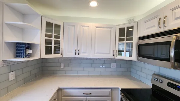 a kitchen with granite countertop a stove a sink and a microwave