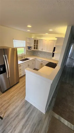 a view of a kitchen with wooden floor and electronic appliances