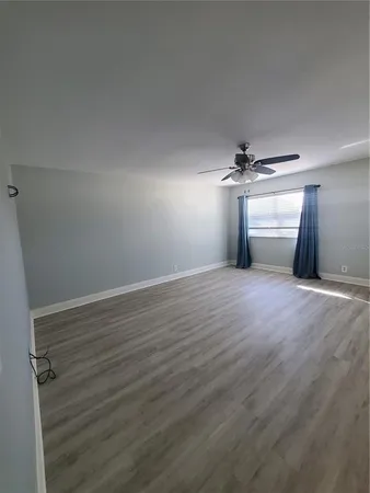 a view of empty room with wooden floor
