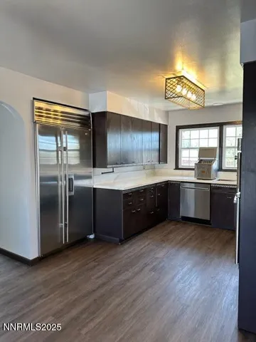 a kitchen with stainless steel appliances a sink cabinets and wooden floor