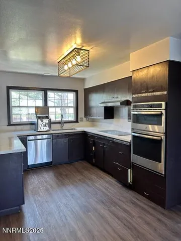 a kitchen with stainless steel appliances kitchen island granite countertop a stove a sink and a refrigerator
